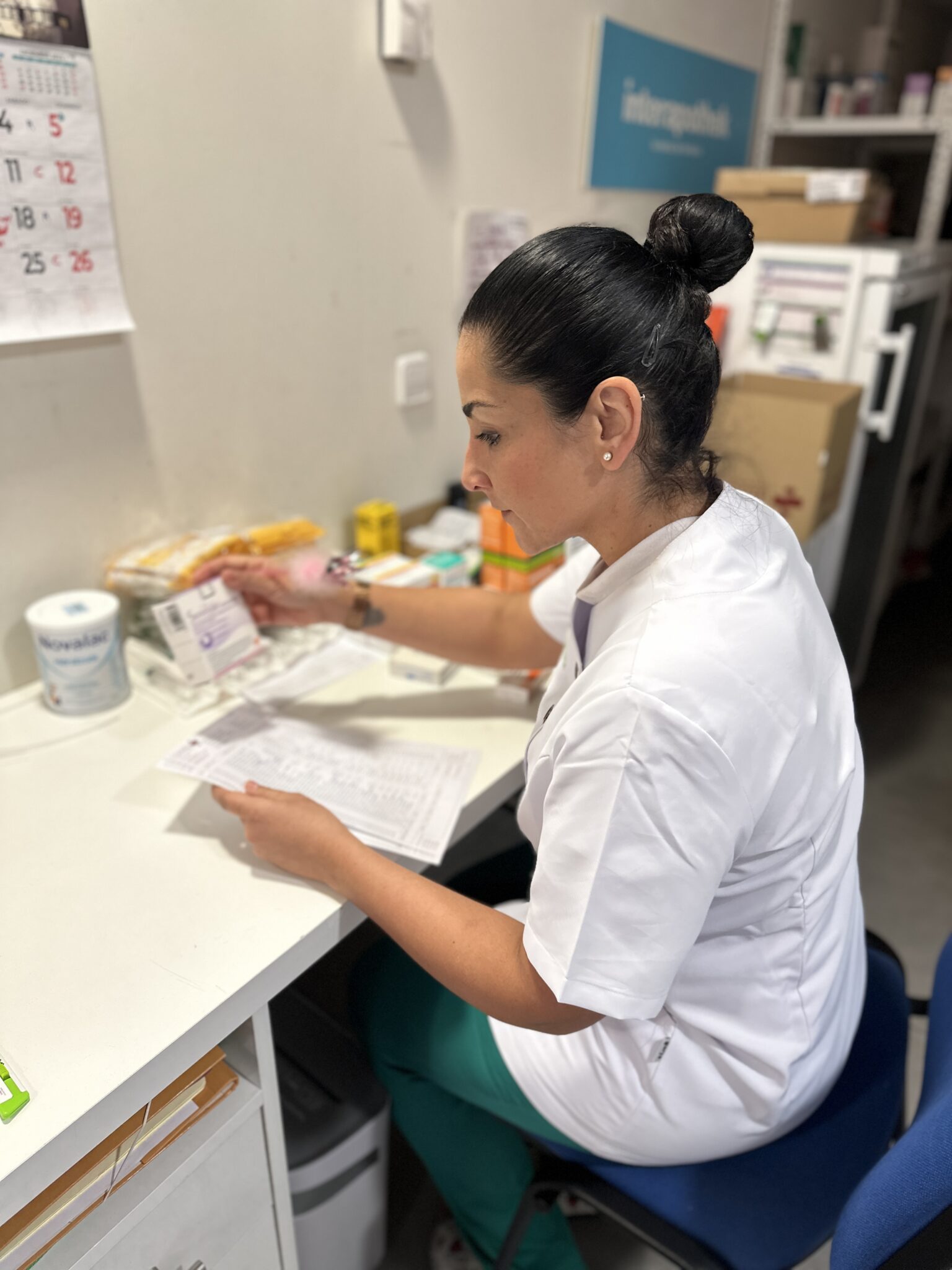 Farmacéutica sentada comprobando pedido de medicamentos